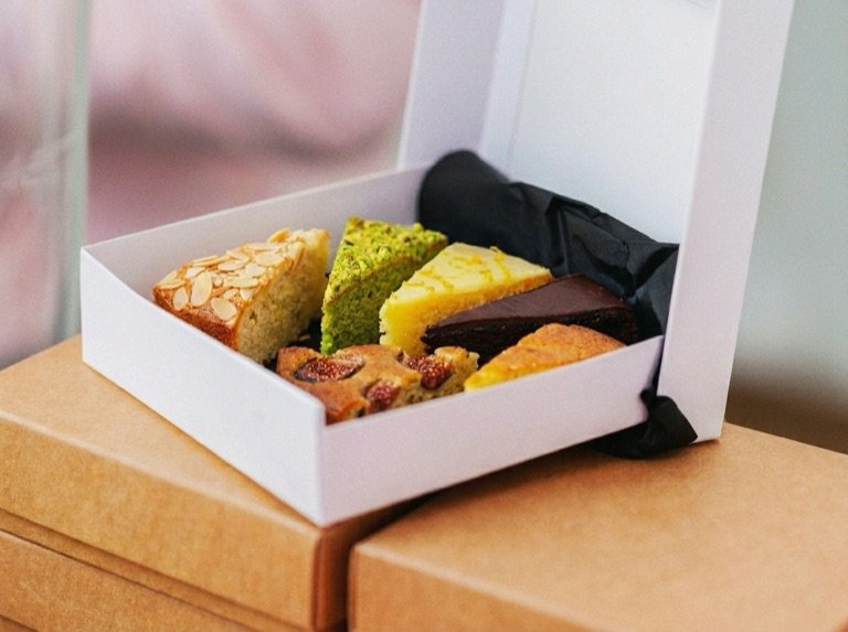 A tasting box of cake slices in several flavours on the studio bench