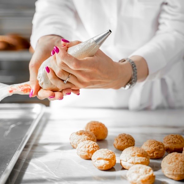 Hands setting a single sugar flower onto a finished tier