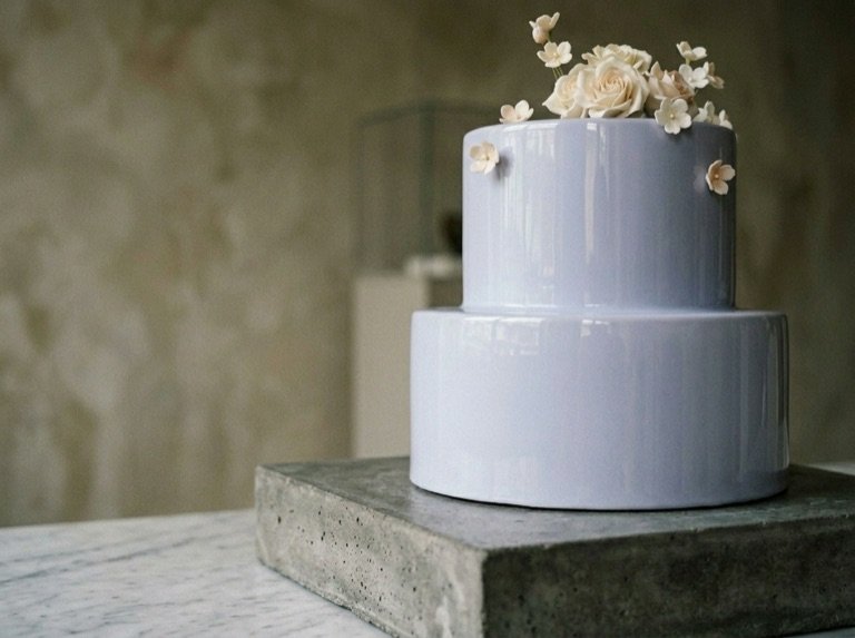 Two-tier pale periwinkle lacquered cake with nine hand-set sugar flowers